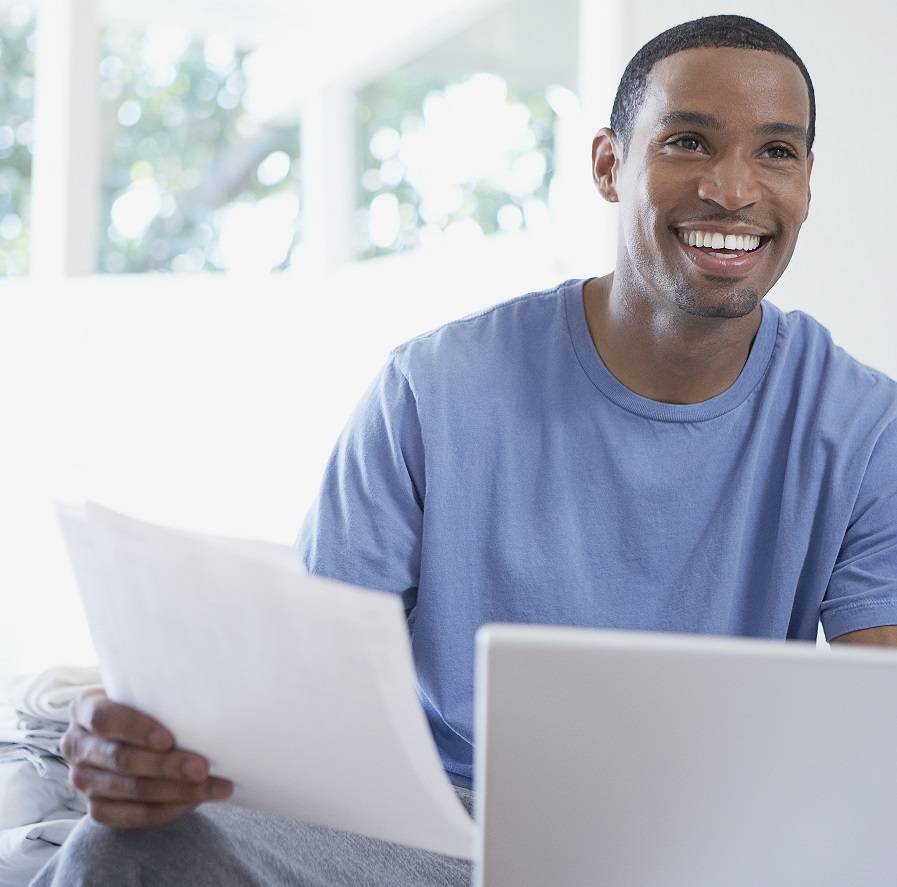 Man smiling while holding papers