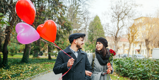 couple holding heart-shaped balloons