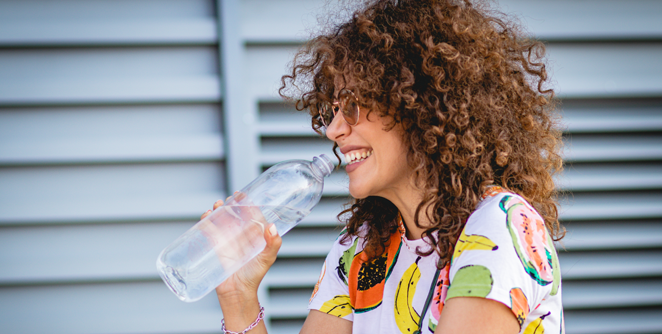 Woman smiling while drinking water