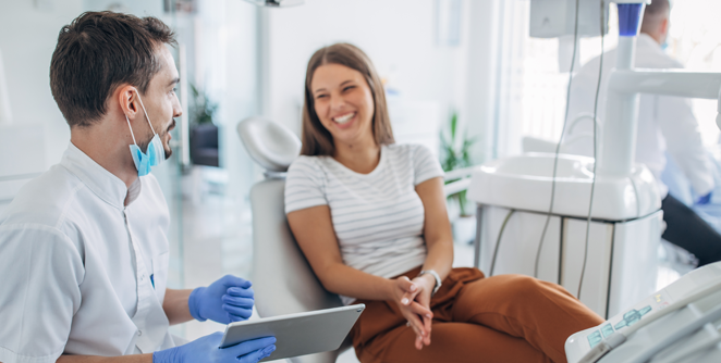 Dentist and patient smiling in a dental office
